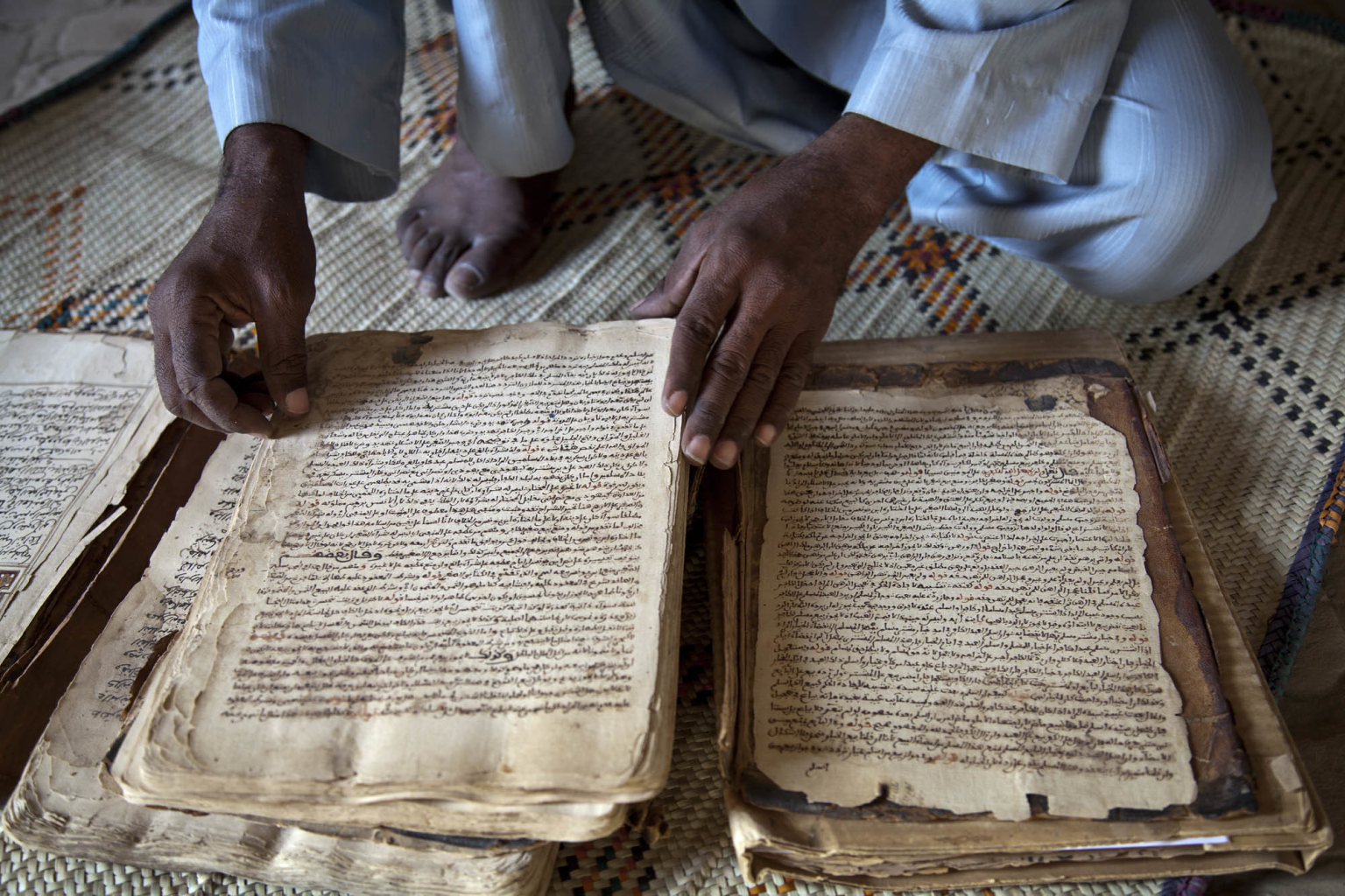 Abdul Wahid shows a manuscript from 14th century at his house in Timbuktu, North of Mali. Image credit Marco Dormino for MINUSMA via Flickr CC BY-NC-SA 2.0.